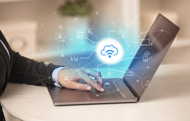 Business woman in homey environment using laptop with  online storage and cloud technology concept
