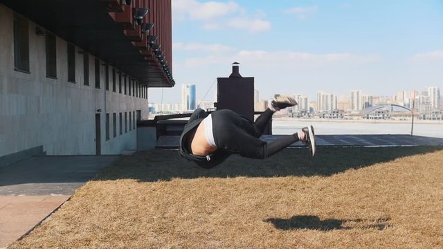 A young man performing acrobatic tricks on the grass