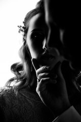 Closeup portrait of bride and groom. A man holds a beautiful girl by the chin