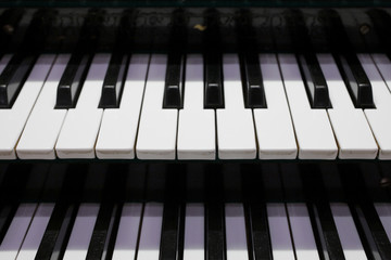 Two rows of pipe organ piano keyboard, closeup view, shallow depth of field