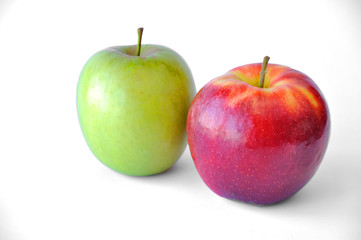 two apples, a green and a red apple are lying on a white table with a background