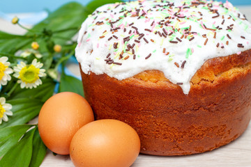 Easter cake and colored eggs yellow flower blossoms on background. Holiday food and easter concept. Selective focus. Copyspase
