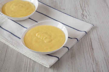 Homemade vanilla custard pudding in white bowls, low angle view. Copy space.