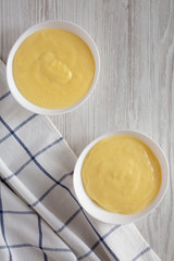 Homemade vanilla custard pudding in white bowls, top view. Overhead, from above, flat lay.
