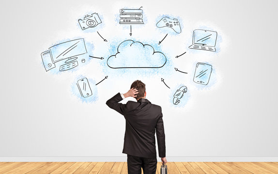 Young businessman in doubt looking to a wall with cloud technology concept
