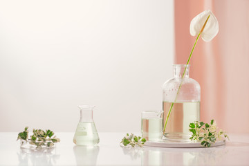 Perfume oils concept. Laboratory glassware with infused floral water on table