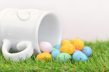 White love heart mug with mini easter eggs on grass