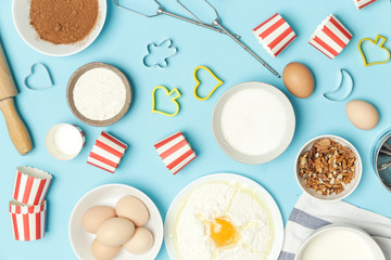 Creating a recipe, Top view of the basic baking ingredients and kitchen utensils on the blue table, cooking concept