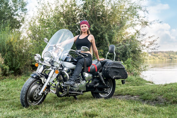 A beautiful blonde woman sitting on a motorcycle
