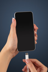 Close-up view of hand charging smartphone