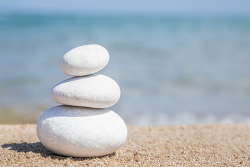 Fototapeta na wymiar stack of pebble stones on balance on sandy beach