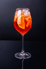 Aperol spritz cocktail in glass on black reflection background. - 264548661