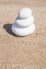 Fototapeta na wymiar stack of pebble stones on balance on a sandy beach with copy space