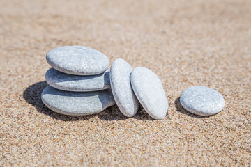 Fototapeta na wymiar stack of pebble stones unbalanced on a sandy beach