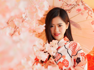 Portrait of attractive Chinese woman wearing traditional Japanese Kimono, smiling at camera,...