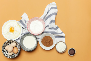 Creating a recipe, Top view of the basic baking ingredients on the orange table, cooking concept. 