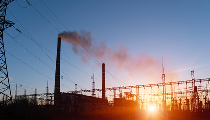 distribution electric substation with power lines and transformers, at sunset