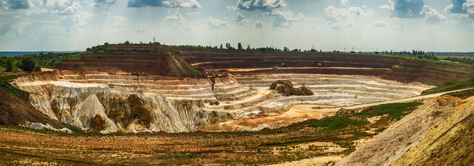 Excavator loading dump truck with raw kaolin in kaolin open pit