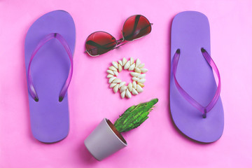Beach purple flip flops, aviator sunglasses, seashell bracelet and succulent cacti cactus on a pink background. Summer vacation colorful travel beach flat lay