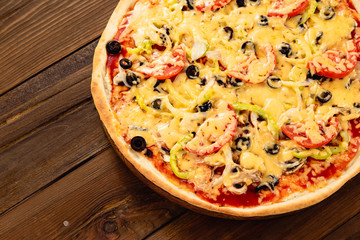 Appetizing pizza on a wooden background