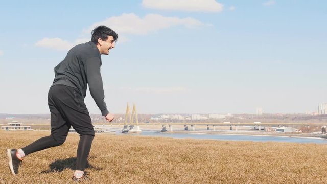 A man in black clothes performing acrobatic tricks on the grass