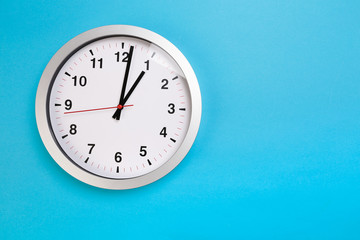 Obraz na płótnie Canvas Closeup wall clock set on blue background. The concept of 