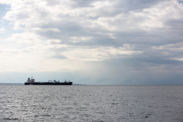 Cargo ship in calm sea with clouds, blank for text