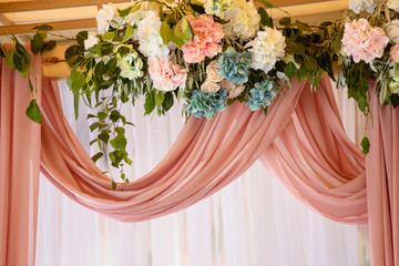 Wedding decoration ceremony. Arch of flowers on the summer area of the restaurant