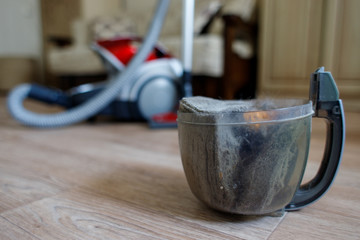 Trash and dust into the plastic cleaner container. Close up