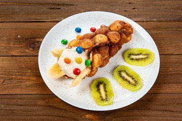 Ice cream ice cream in a waffle cone with sweets and fruit syrup