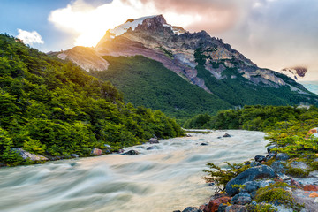 Sun is setting over the mountains and Fitz Roy river at Los Glaciares National Park
