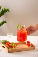 Hand hold watermelon juice with watermelon fruit