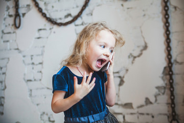 Little girl emotional talking on mobile phone.