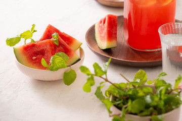 Watermelon drink in glass with slices of watermelon on whitebackground