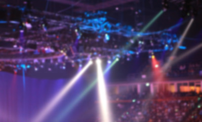 Blurred Concert light with colored spotlights and smoke.