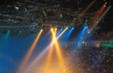 Blurred Concert light with colored spotlights and smoke.