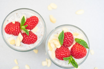 chia pudding with raspberries in a small glass bowl