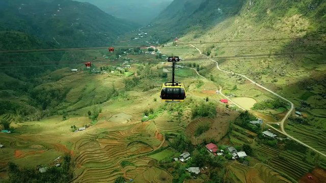 Aerial around cable car cabin to Fansipan legend beautiful rice green fields plantation drawing texture cascades between mountains canyon natural landscape. Trip Sapa Vietnam old village