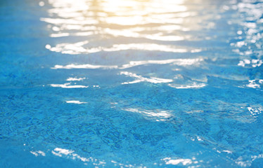 Abstract ripples on wimming pool surface with light reflection.