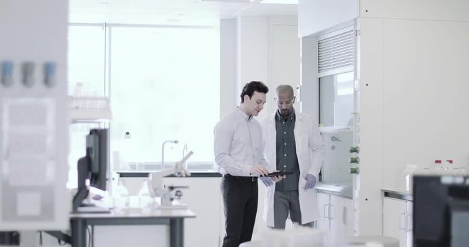 Scientists looking at data on a digital tablet