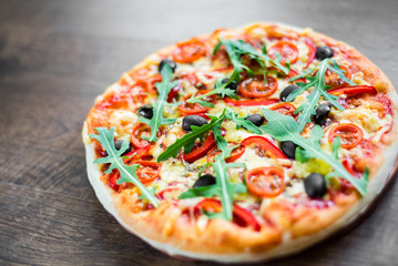 Pizza Margherita or Margarita with Mozzarella cheese, tomato, olive. Italian pizza on wooden background