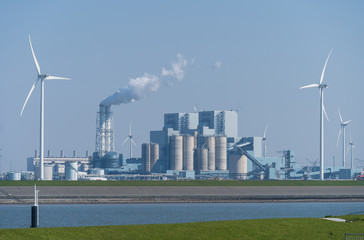 Fossile fuel (coal) power station and wind turbines in the Eemsharbor Eemshaven, Groningen, Holland.