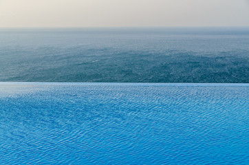 Obraz premium Infinity pool with crystal blue water view to sea ocean