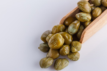 Pickled capers on a white acrylic background