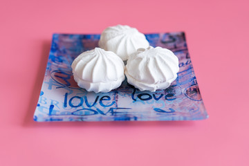 Pink and white marshmallows on a pink background