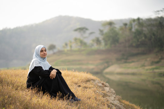 beautiful woman with hijab sitting outdoor enjoy nature in the morning