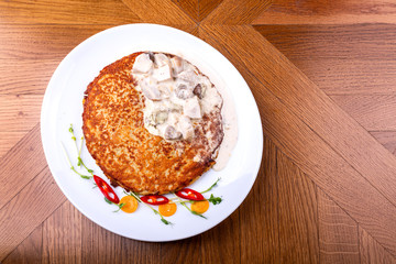 Potato pancakes in white mushroom sauce. Draniki - potato fritters. potato pancakes. The naitonal dish of Belarus, Ukraine and Russia. Top view