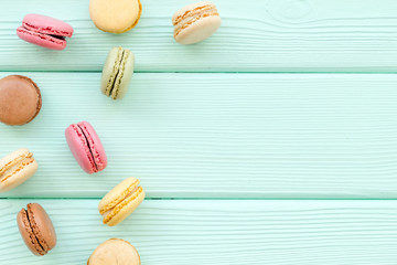 Macarons dessert pattern on mint green background top view copy space