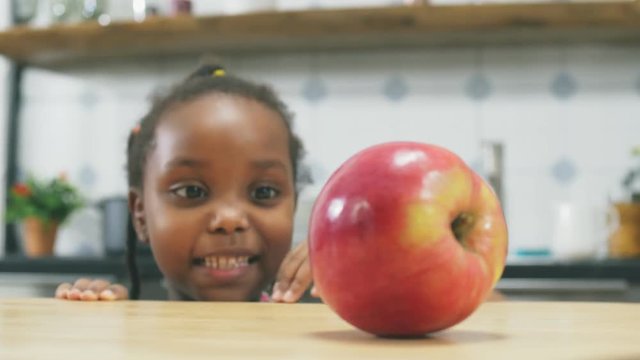 Little girl taking apple