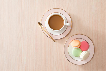 Fototapeta na wymiar Cup of coffee with macaroons on wooden background